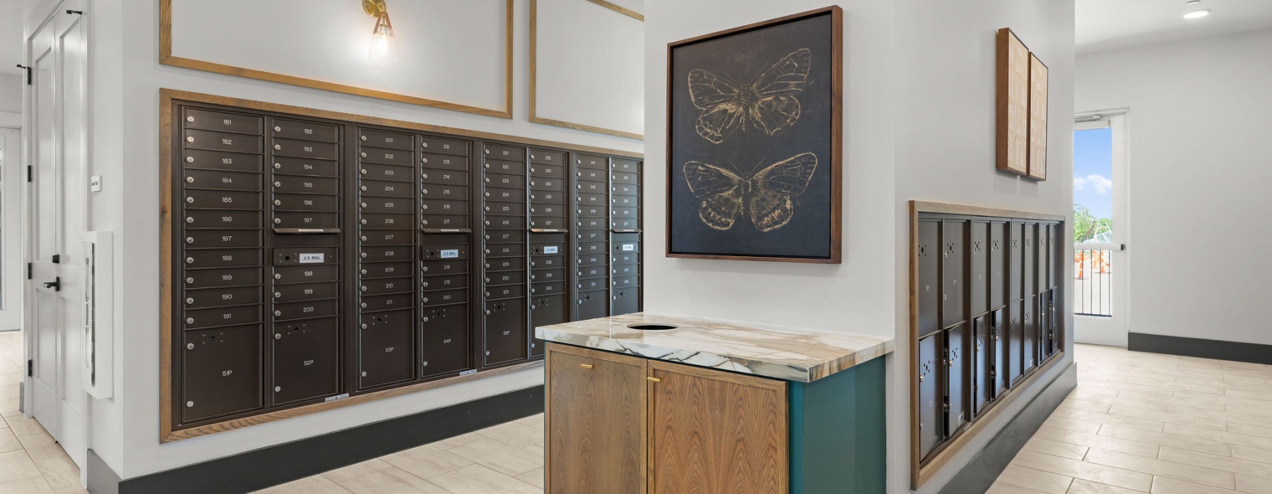 a room with a cabinet and a tablea spacious mail room with ample light